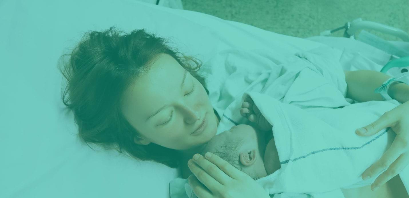 A woman in a hospital bed holding a new born baby