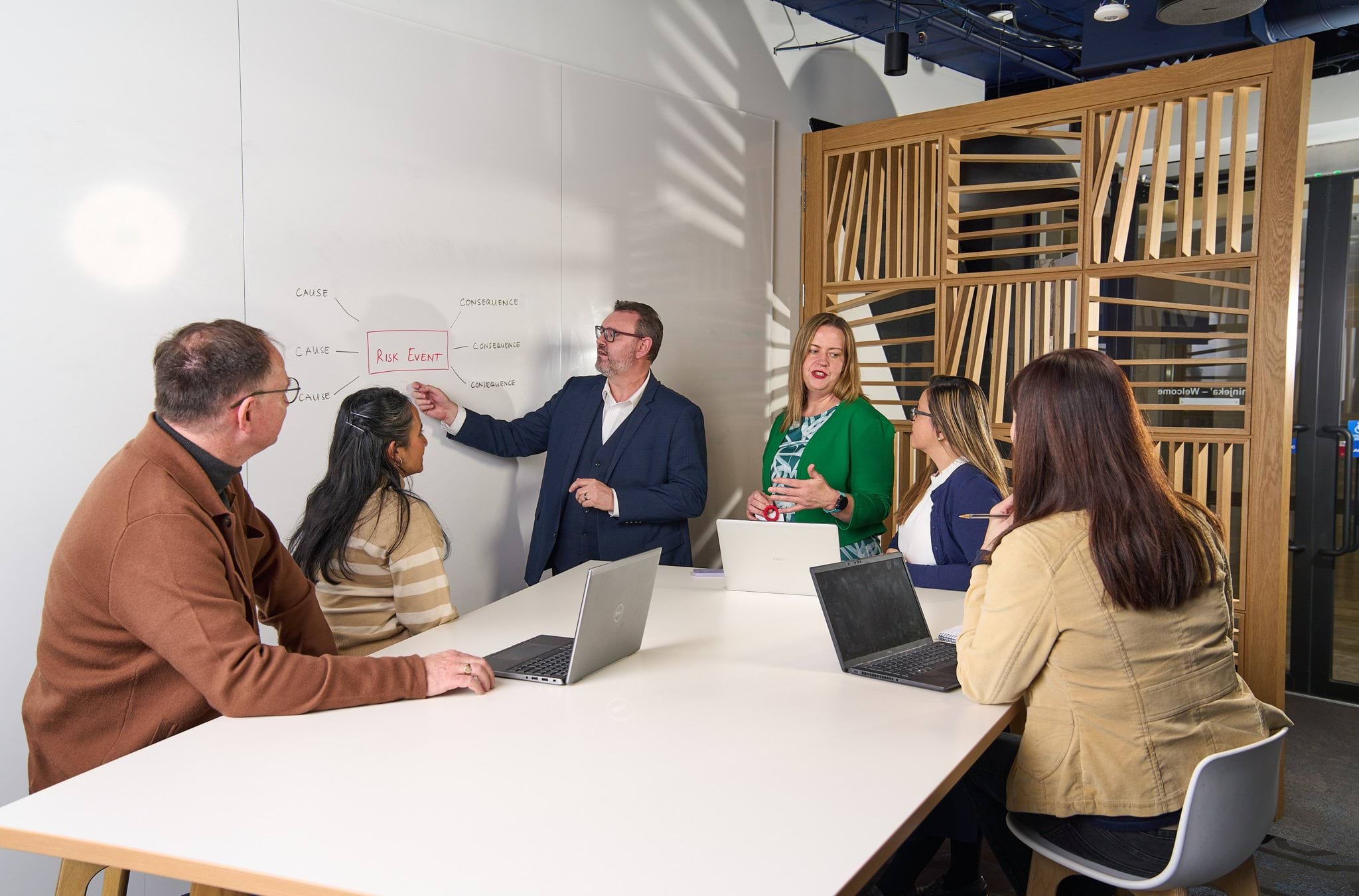 Educator standing at a whiteboard giving a risk workshop